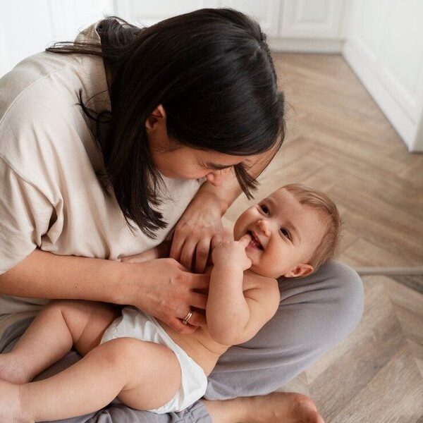 A mother playing with her smiling baby